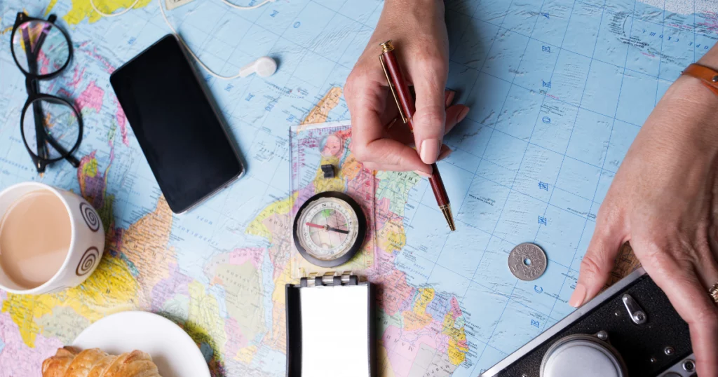 photo d'une personne qui résout des problèmes d'internet en voyage aux usa : la photo montre des mains, un téléphone, un crayon et une carte.